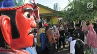 Warga berfoto di dekat ondel-ondel saat Lebaran Betawi di Monas, Jakarta, Minggu (21/7/2019).Untuk pertama kalinya Lebaran Betawi digelar di Monas yang diisi oleh beragam seni dan budaya masyarakat Betawi dalam rangka memeriahkan HUT DKI Jakarta. (merdeka.com/Iqbal S. Nugroho)