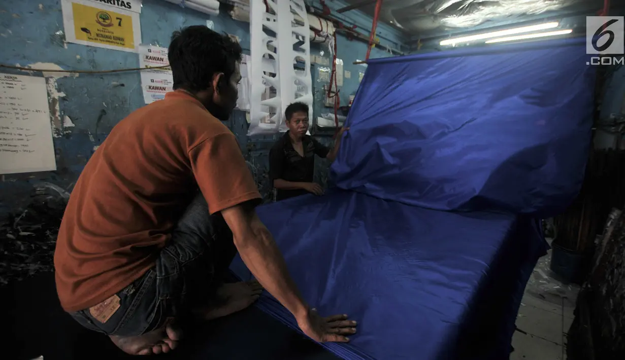 Aktivitas pekerja saat menyelesaikan sablon bendera partai politik di Percetakan Andalas Jaya, Jakarta, Rabu (2/1). Pedagang mengaku pemesanan naik hingga 60 persen dari bulan biasa. (Merdeka.com/Iqbal Nugroho)