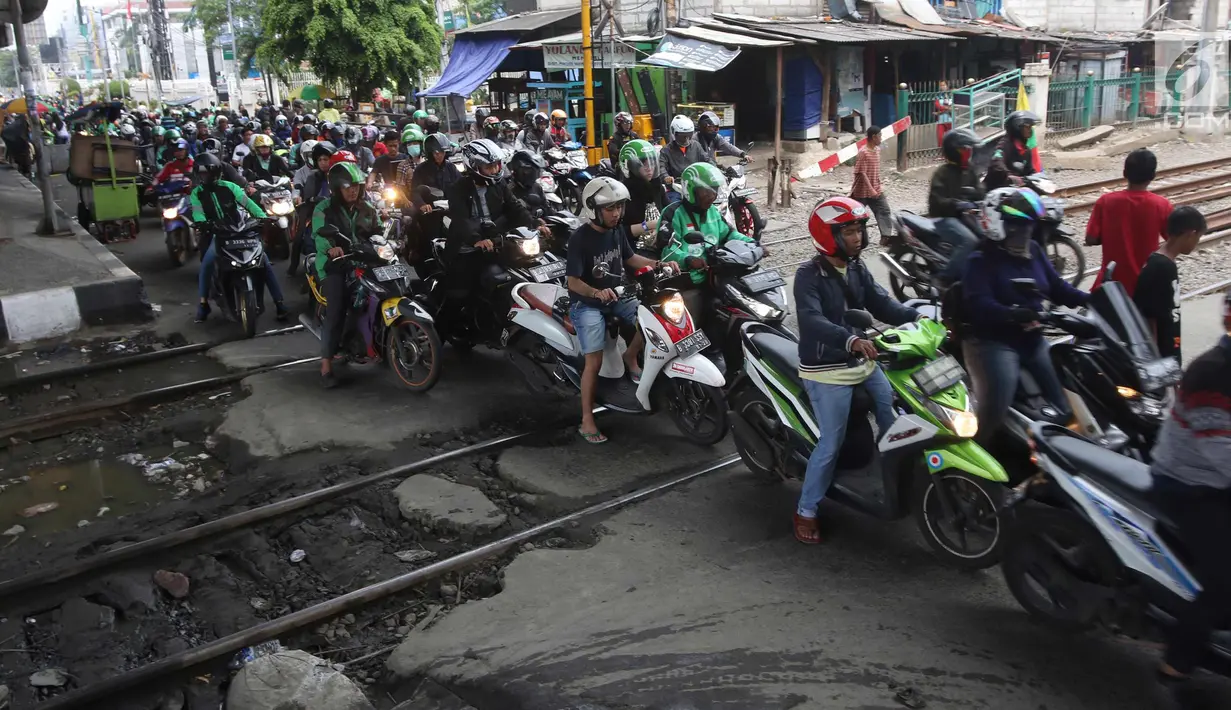 Pengendara motor melintas di perlintasan kereta api yang tidak berpalang pintu di kawasan Roxy, Jakarta, Rabu (21/3). Akhirnya antara warga dan petugas menyepakati untuk membuka celah selebar dua meter di lokasi tersebut. (Liputan6.com/Arya Manggala)