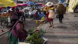 Perempuan menunggu pelanggan sambil menjual buah dan sayuran di pasar makanan populer di Puno, Peru, Minggu (29/1/2023). Pemerintah Peru membatasi kebebasan termasuk hak untuk berkumpul, setelah berminggu-minggu gejolak protes yang telah menewaskan sejumlah korban jiwa. (AP Photo/Rodrigo Abd)