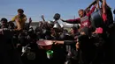 Warga Palestina menunggu bantuan gula dan beras di dapur umum di Khan Younis, Jalur Gaza selatan, Jumat, 31 Oktober 2025. Namun, sering kali, makanan yang tersedia seperti sup, nasi, atau lentil rebus, sangat terbatas dan banyak yang pulang dengan tangan kosong karena kehabisan. (AP Photo/Abdel Kareem Hana)