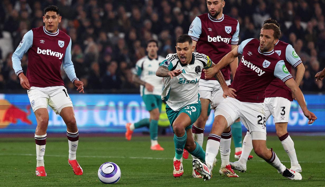 Pemain Newcastle, Bruno Guimaraes menggiring bola melewati sejumlah pemain West Ham dalam laga lanjutan Liga Inggris 2024/2025 di London Stadium, London, Inggris, Selasa (11/03/2025) dini hari WIB. (AFP/Adrian Dennis)