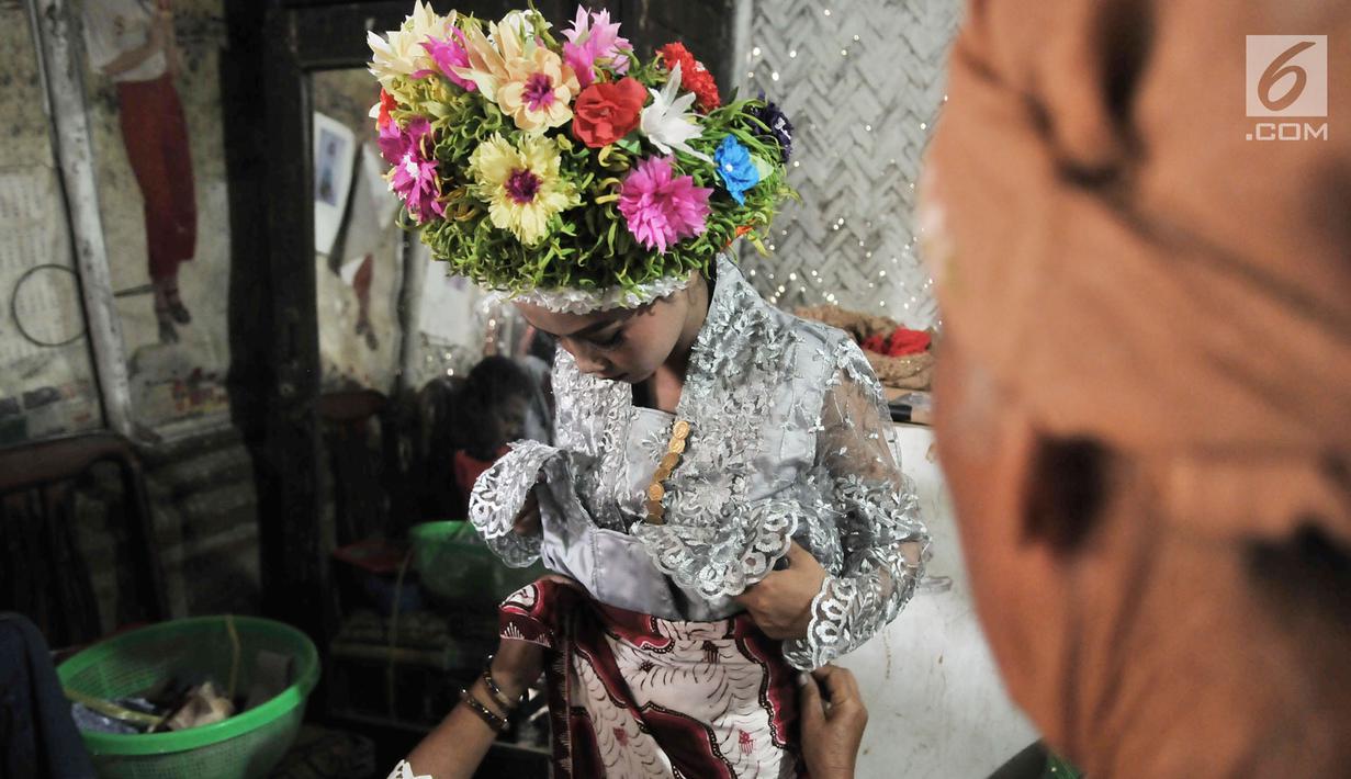 Gadis dirias oleh keluarga sebelum mengikuti Upacara Adat Ngarot di Desa Lelea, Kabupaten Indramayu, Jawa Barat, Rabu (19/12). Para gadis didandani mengenakan setelan kebaya dan kain batik dipadu dengan selendang. (Merdeka.com/Iqbal Nugroho)