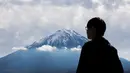 Turis melihat Gunung Fuji dari Fujikawaguchiko, Prefektur Yamanashi (1/11). Gunung Fuji adalah simbol Jepang yang terkenal dan sering digambarkan dalam karya seni dan foto-foto, serta dikunjungi pendaki gunung maupun wisatawan. (AFP Photo/Behrouz Mehri)