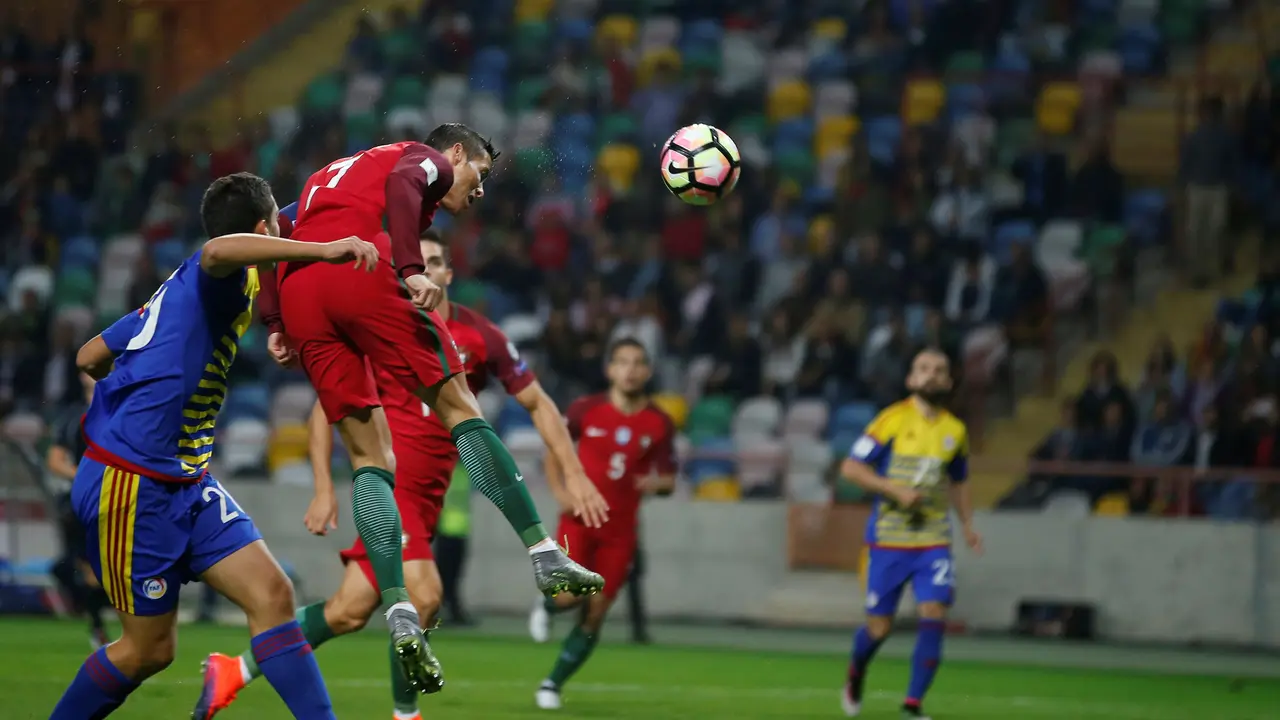 Cristiano Ronaldo menanduk bola ke arah gawang Andorra