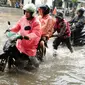 Seorang petugas membantu mendorong sepeda motor yang menerobos banjir di kawasan Kemang, Jakarta, Selasa (4/10). Hujan deras yang mengguyur Jakarta dan meluapnya kali Krukut menyebabkan wilayah Kemang kembali terendam banjir. (Liputan6.com/Gempur M Surya)