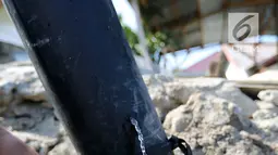 Warga memanfaatkan air bersih dari kebocoran pipa PDAM di Jalan Lagarutu, Palu Sulawesi Tengah, Rabu (3/10). Mereka mengisi air dari pipa PDAM menggunakan selang yang disalurkan ke dalam galon. (Liputan6.com/Fery Pradolo)