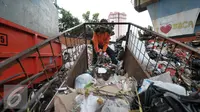 Petugas kebersihan mengumpulkan sampah di lokasi tempat pembuangan sampah sementara (TPSS), Pasar Baru, Jakarta, Jumat (25/11). Pengelolaan sampah menjadi pekerjaan rumah bagi calon gubernur DKI Jakarta yang terpilih nanti. (Liputan6.com/Yoppy Renato)