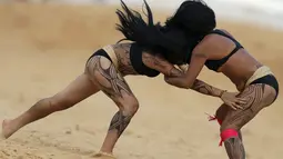 Dua wanita adat sedang bergulat dalam pertandingan yang disebut Huka Huka pada Olimpiade bagi Masyarakat adat, Palmas, Brasil, (30/10/2015). Masyarakat adat dari 22 negara di dunia ikut memeriahkan acara ini. (REUTERS/Ueslei Marcelino)
