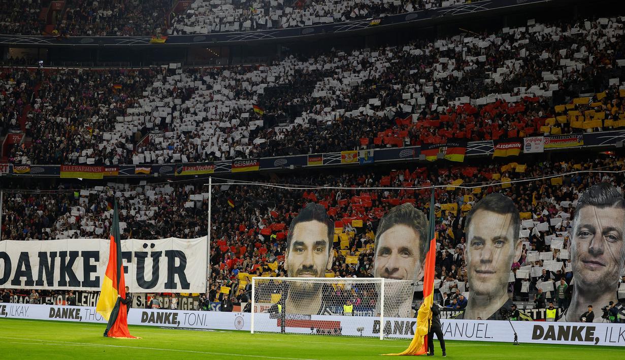 Suporter Timnas Jerman melakukan aksi berkelas dengan membuat koreografi wajah para pemain Tim Panzer yang memutuskan pensiun dari sepak bola Internasional saat laga Grup 3 UEFA Nations League 2024/2025 melawan Belanda di Allianz Arena, Munchen, Selasa (15/10/2024). (AFP/Odd Andersen)