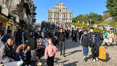 Pelancong dari China daratan berkumpul dekat Reruntuhan St. Paul's, tujuan wisata di Makau, 18 Januari 2022. Ledakan pariwisata China yang diharapkan selama liburan Tahun Baru Imlek minggu depan tampaknya akan lebih cepat terjadi. (AP Photo/Kanis Leung)