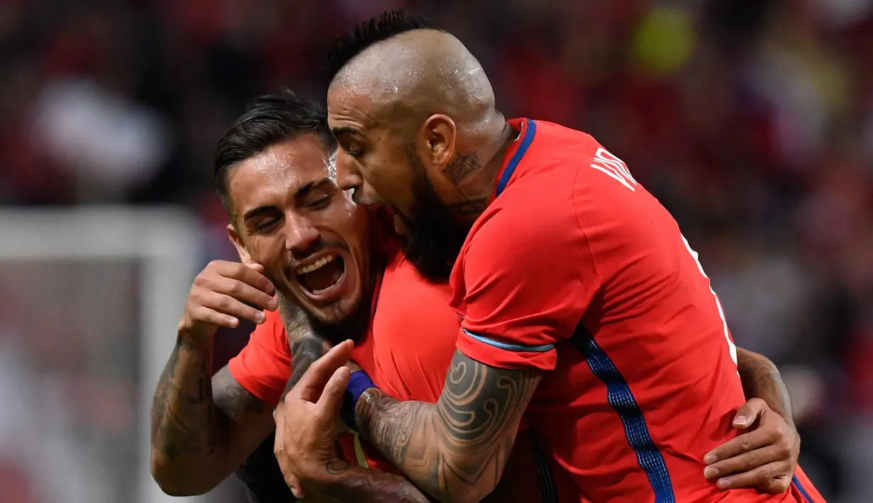 Penyerang Chile, Marcos Bolados (kiri) melakukan selebrasi dengan rekannya Arturo Vidal usai mencetak gol ke gawang Swedia pada pertandingan persahabatan internasional di Friends Arena, Stockholm, (24/3). Chile menang 2-1. (Anders Wiklund/TT via AP)