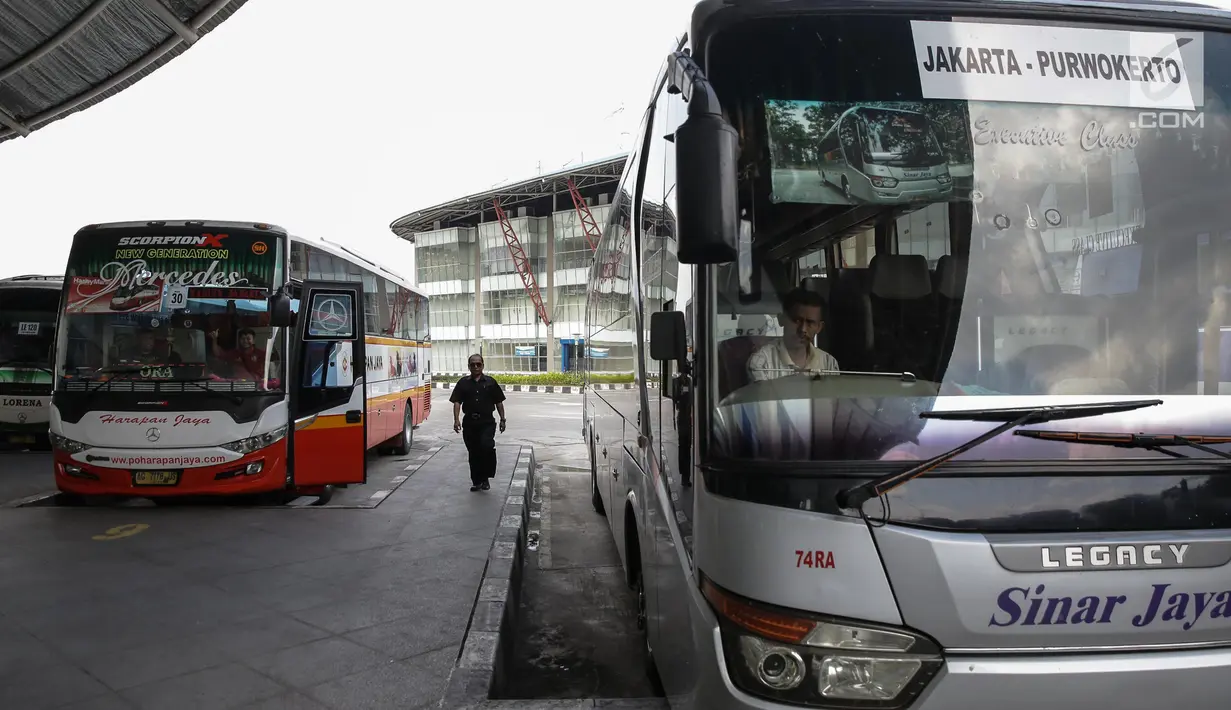 Seorang pria berjalan di antara bus Antar Kota Antar Provinsi (AKAP) di Terminal Pulo Gebang, Jakarta, Kamis (8/6). Pemprov DKI Jakarta menyiapkan terminal Pulo Gebang sebagai pusat pemberangkatan mudik Lebaran 2017. (Liputan6.com/Faizal Fanani)