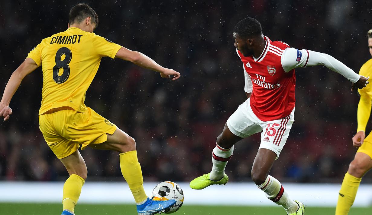 Gelandang Standard Liege, Gojko Cimirot, berebut bola dengan gelandang Arsenal, Ainsley Maitland-Niles, pada laga Liga Europa di Stadion Emirates, London, Kamis (3/10). Arsenal menang 4-0 atas Liege. (AFP/Glyn Kirk)