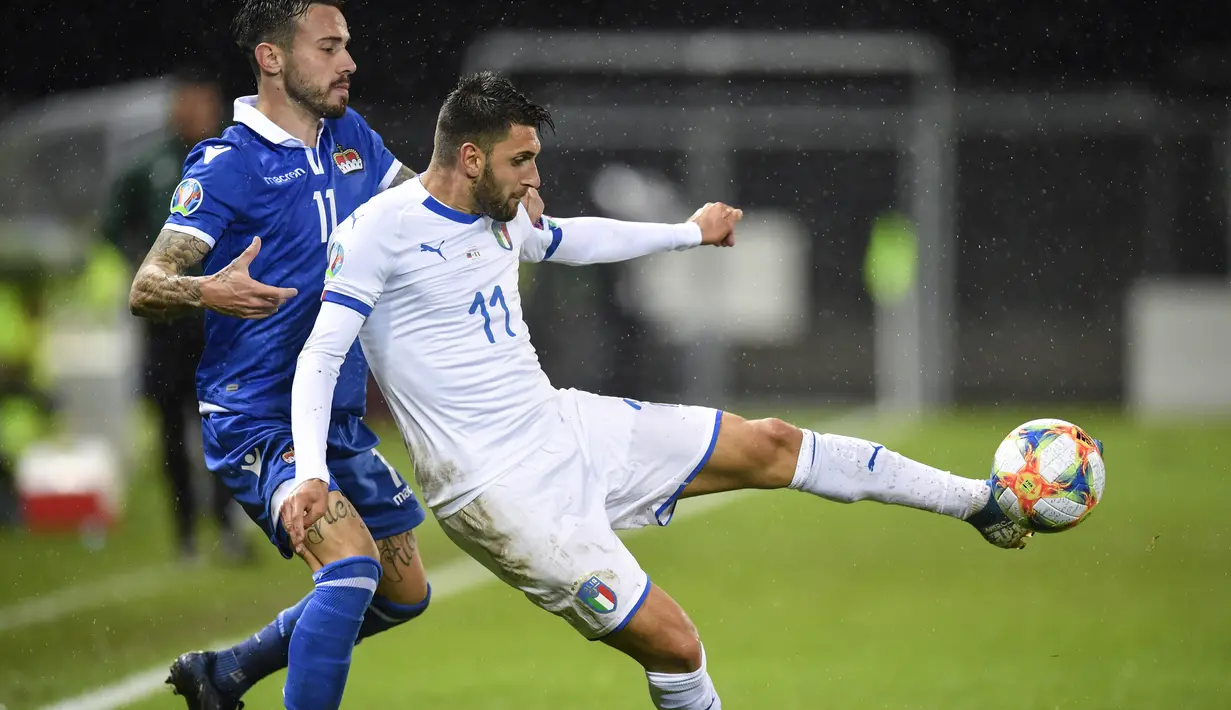 Pemain Liechtenstein, Dennis Salanovic berusaha merebut bola yang dibawa pemain Italia, Vincenzo Grifo selama bertanding pada Grup J Kualifikasi Piala Eropa 2020 di Vaduz, Liechtenstein (15/10/2019). Italia menang telak 5-0 atas Liechtenstein. (Gian Ehrenzeller/Keystone via AP)