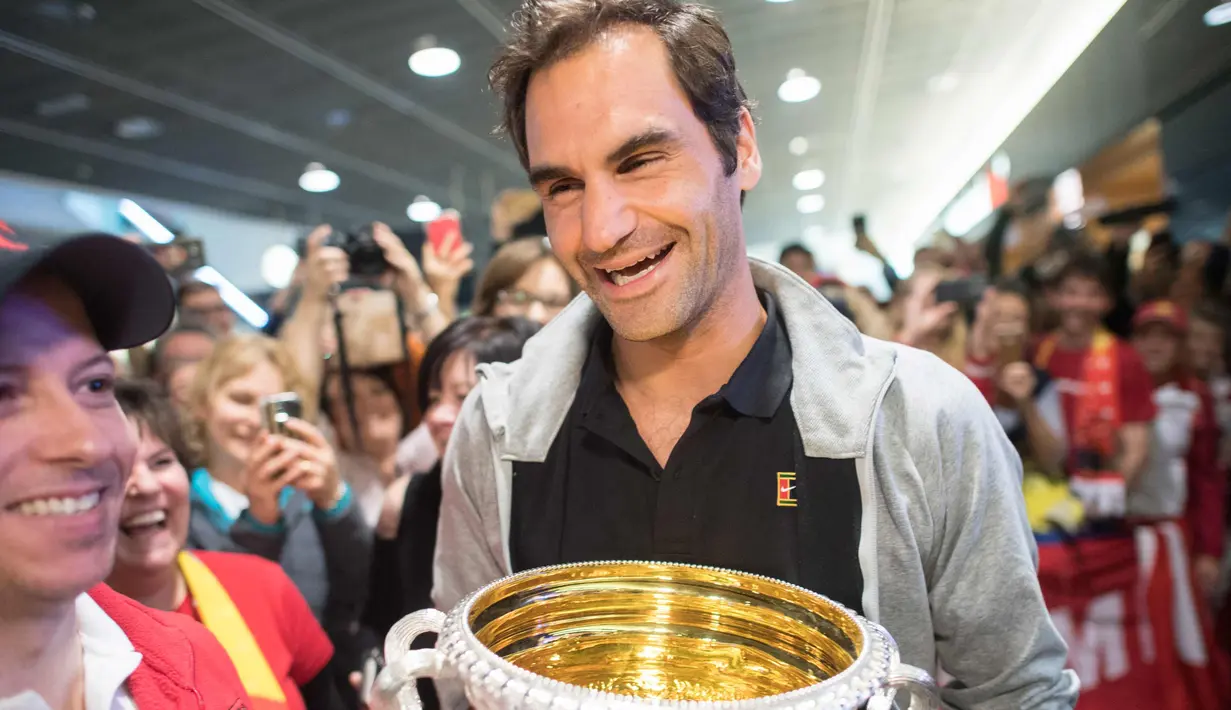 Petenis Swiss Roger Federer membawa trofi Australia Terbuka saat disambut penggemar di Bandara Zurich, di Kloten, Swiss, (30/1). Federer memenangkan final tunggal putramelawan petenis Kroasia Marin Cilic. (Ennio Leanza/Keystone via AP)