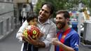 Reza Parastesh, seorang warga Iran yang memiliki wajah mirip Lionel Messi diajak foto bareng oleh warga di jalanan Tehran, Iran, Senin (8/5/2017). (AFP/Atta Kenare)