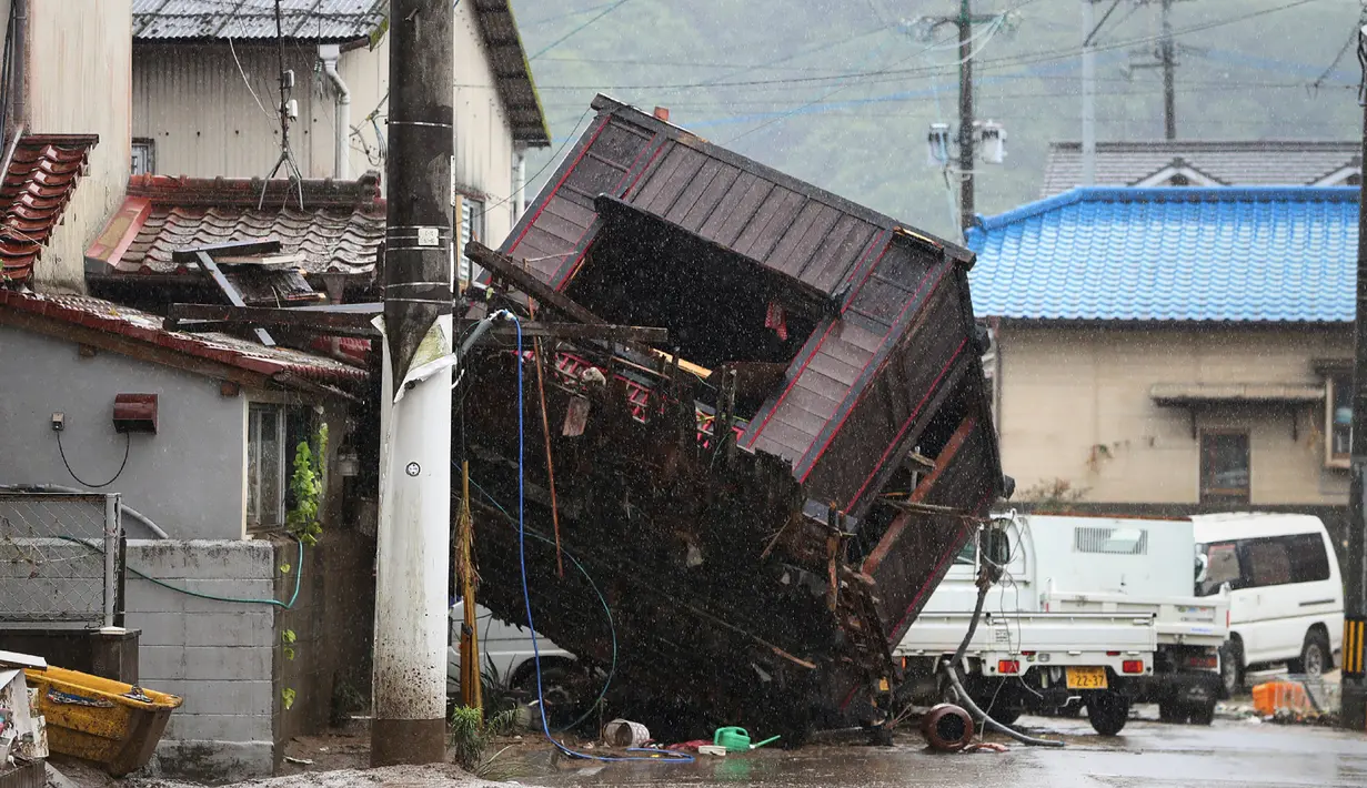 Kerangka bangunan tersapu banjir yang disebabkan hujan lebat di sebuah jalan di Hitoyoshi, prefektur Kumamoto, Jepang, Minggu (5/7/2020). Banjir di wilayah Kumamoto yang memicu tanah longsor ini telah menghancurkan ratusan rumah dan kendaraan serta membuat jembatan terputus. (STR/JIJI PRESS/AFP)