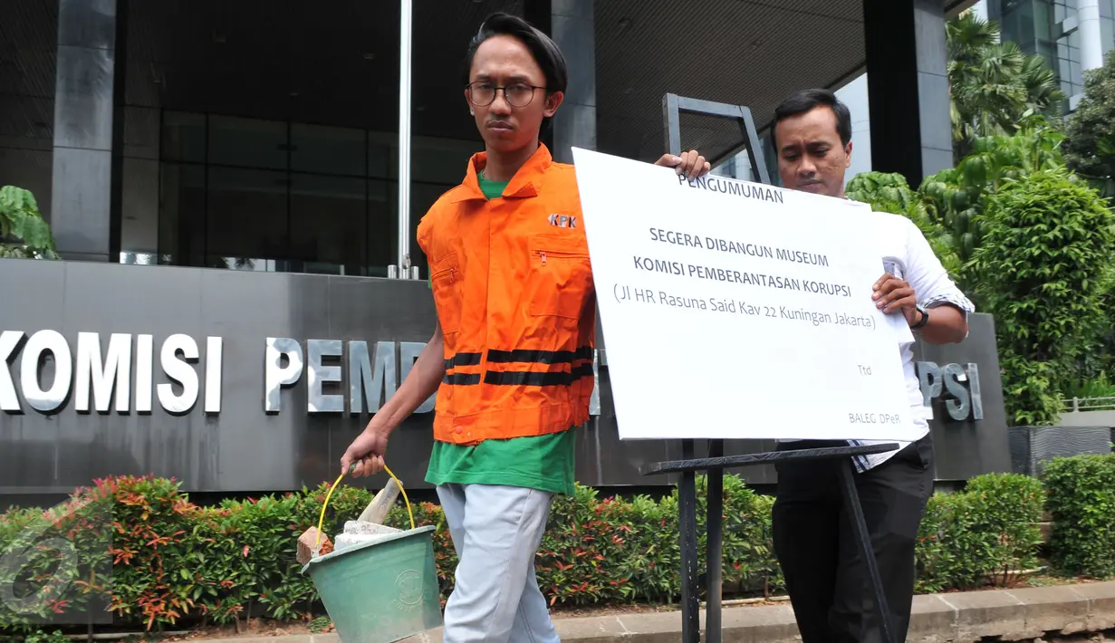 Dua orang dari Anggota Koalisi Pemantau Peradilan membawa papan pengumuman, Jakarta, Kamis (8/10/2015). Mereka memprotes DPR yang berencana merevisi UU KPK NO.30 th 2002 (Liputan6.com/Andrian M Tunay)