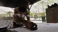 Ahdin Sirua, pengrajin batik cetak motif lokal Sulteng saat mengerjakan kain batik motif Taiganja khas suku kaili di rumahnya di jalan Lekatu, Palu, Kamis (5/11/2020). (Foto: Liputan6.com/ Heri Susanto).
