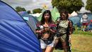 Dua wanita keluar dari tenda selama Festival Glastonbury di Worthy Farm, Somerset, Inggris (30/6/2019). Festival Glastonbury merupakan festival musik paling populer di dunia yang berlangsung lima hari. (AFP Photo/Oli Scarff)