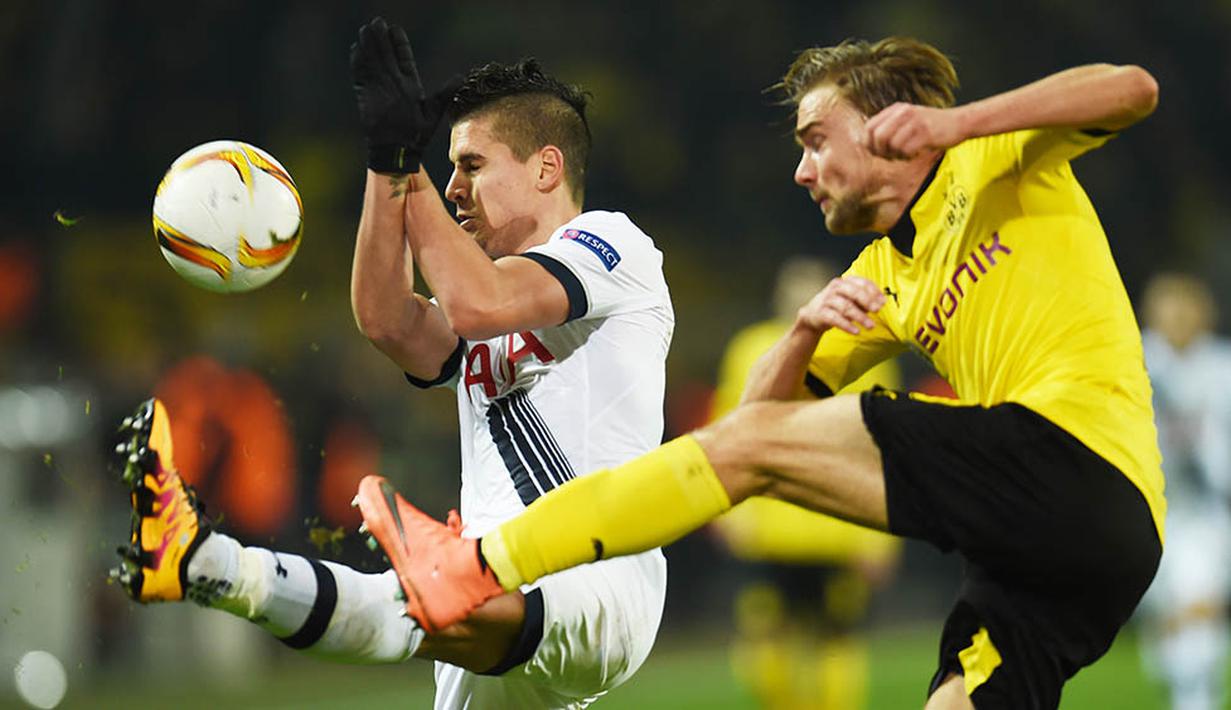 Bek Dortmund, Marcel Schmelzer, berebut bola dengan gelandang Tottenham, Erik Lamela. Pada laga itu Dortmund lebih menguasai jalannya pertandingan dengan penguasaan bola 65 persen. (AFP/Patrik Stollarz)
