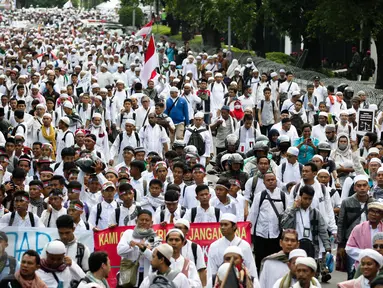 Massa demo 2 Desember mulai berjalan kaki menuju Monumen Nasional (Monas), Jakarta Pusat, Jumat (2/12). Dengan mengenakan pakaian serba putih, peserta demo 2 Desember sesekali mengucapkan kalimat takbir. (Liputan6.com/Faizal Fanani)