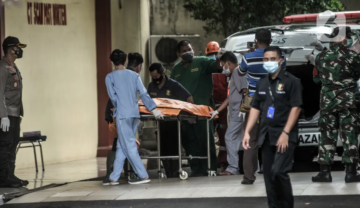 Tim forensik menurunkan kantong jenazah berisi serpihan Sriwijaya Air SJ 182 dan diduga tubuh korban dari ambulans di RS Polri, Jakarta, Minggu (10/1/2021). RS Polri menerima tiga kantong jenazah berisi serpihan pesawat dan diduga tubuh korban untuk diidentifikasi. (merdeka.com/Iqbal S. Nugroho)