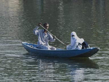 Seorang pria mendayung perahu selama jam sekolah di Danau Dal di Srinagar, India, Rabu (11/5/2022). Danau terbesar di negara bagian tersebut penting untuk kegiatan perikanan, perairan, rekreasi, dan pariwisata. (TAUSEEF MUSTAFA / AFP)