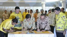 Wapres Jusuf Kalla (tengah) bersama Ketum Partai Golkar versi munas Bali Aburizal Bakrie dan Ketum Partai Golkar versi munas Ancol Agung Laksono (kedua kiri) saat penandatangan berkas kesepakatan islah di Jakarta, Sabtu (30/5). (Liputan6.com/Johan Tallo)