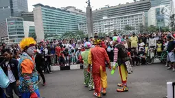 Aksi badut yang tergabung dalam Aku Badut Indonesia menghibur masyarakat saat car free day di Bunderan HI, Jakarta, Minggu (9/12). Aksi tersebut bentuk kampanye positif bertujuan mengajak masyarakat peduli terhadap sesama. (Liputan6.com/Faizal Fanani)