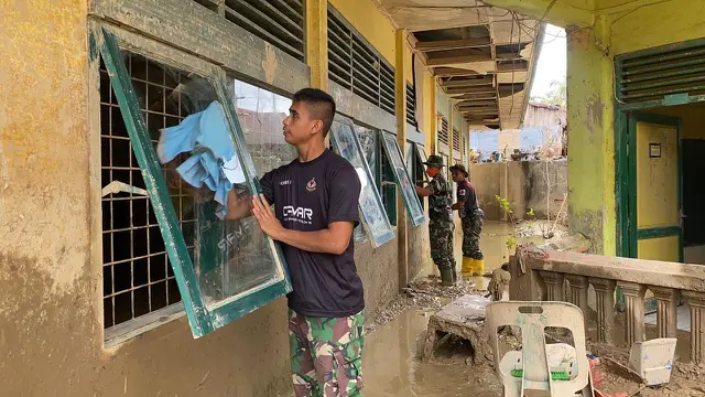 TNI membersihkan sekolah yang dipenuhi lumpur tebal akibat bencana banjir di Aceh Tamiang.