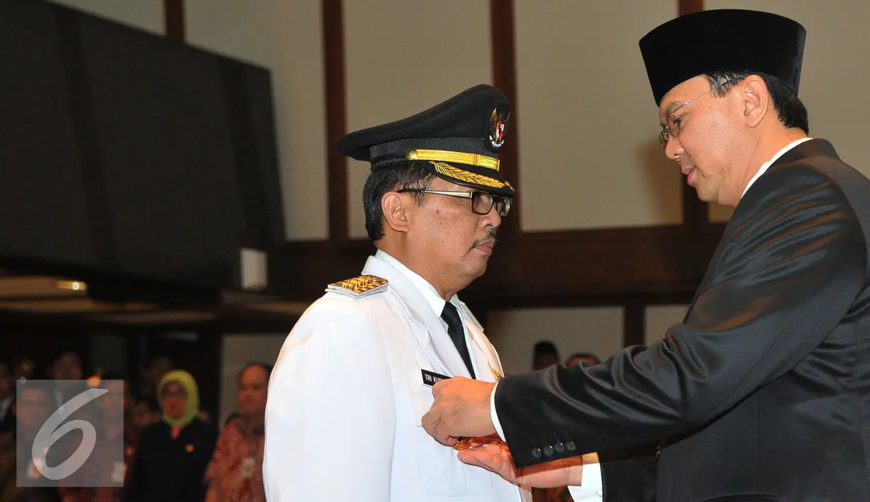 Basuki T Purnama (kanan ) memberikan tanda pangkat ke Wakil Walikota Jaksel Tri Kurniadi (kiri) pada saat pelantikan di balai kota, Jakarta, Kamis (13/8/2015). Tri resmi menggantikan Syamsuddin Noor yang dipecat. (Liputan6.com/Herman Zakharia)
