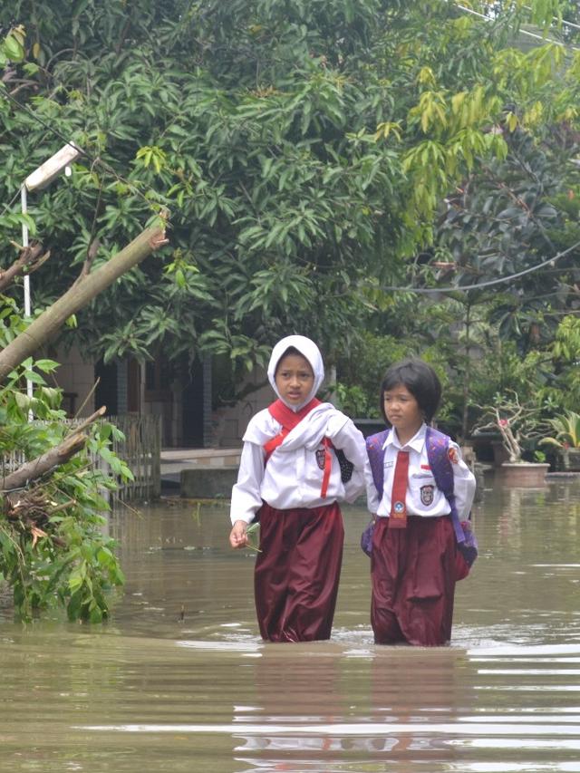 Dua siswa SD menerabas banjir di Sidareja, Cilacap, Jawa Tengah (20/9/2016). (Foto: Liputan6.com/Muhamad Ridlo)