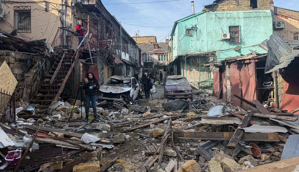 Pihak berwenang setempat melaporkan, sepasang suami istri tewas, sementara 15 lainnya terluka dalam peristiwa ini. Tampak dalam foto, para jurnalis merekam rumah-rumah penduduk yang rusak parah setelah serangan Rusia di Odesa, Ukraina, Jumat 24 April 2026. (AP Photo/Michael Shtekel)