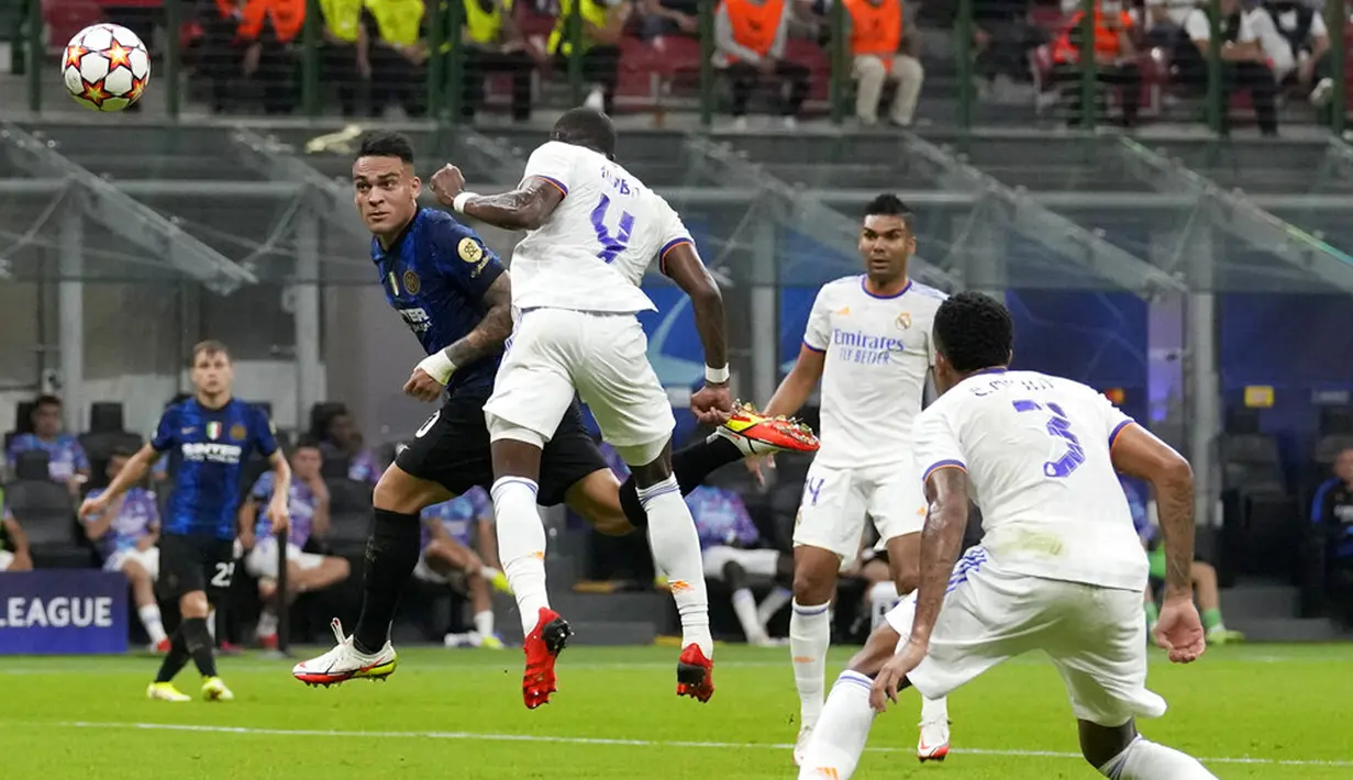 Pemain Inter Milan Lautaro Martinez (kiri) menyundul bola melewati pemain Real Madrid David Alaba pada pertandingan Grup D Liga Champions di Stadion San Siro, Milan, Italia, Rabu (15/9/2021). Real Madrid menang 1-0. (AP Photo/Antonio Calanni)