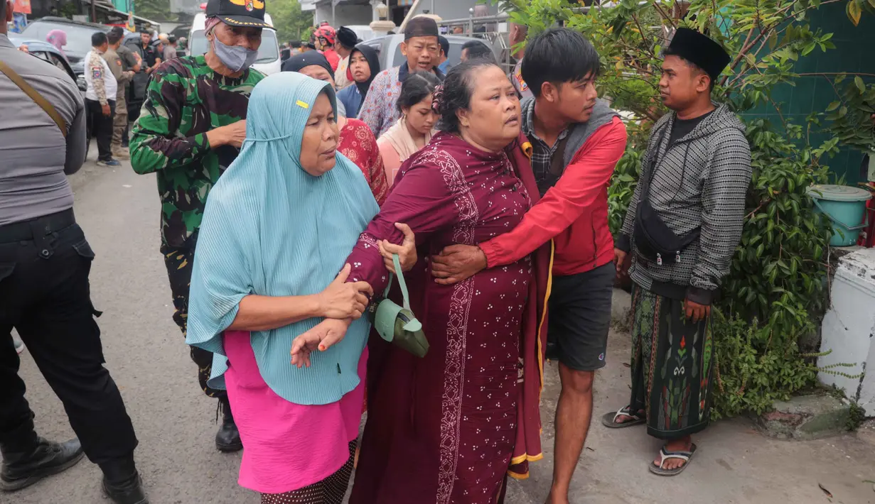 Dari jumlah tersebut, sebanyak 91 di antaranya melakukan evakuasi mandiri sesaat setelah kejadian. Tampak dalam foto, seorang perempuan dibantu untuk berjalan keluar setelah bangunan runtuh di sebuah pesantren di Sidoarjo, Jawa Timur, Selasa 30 September 2025. (AP Photo/Trisnadi)