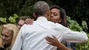 Ibu negara AS Michelle Obama berpelukan dengan sang suami Presiden AS, Barack Obama saat memanen ubi jalar di kebun Gedung Putih, Washington, (6/10). (AFP Photo/Jim Watson)