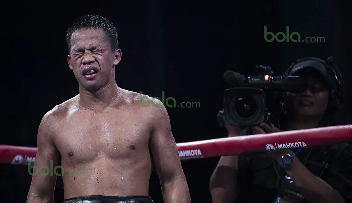 Pelipis Daud Yordan pecah akibat benturan dengan kepala Yoshitaka Kato dan pertandingan terpaksa dihentikan wasit di ronde 9. Daud Yordan berhasil mempertahankan gelar WBO Asia Pasifik dan Afrika dengan kemenangan angka. (Bola.com/Vitalis Yogi Trisna)
