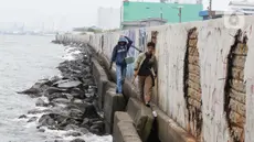 Warga sedang memancing di tanggul laut kawasan Muara Baru, Jakarta, Selasa (4/2/2025). (Liputan6.com/Herman Zakharia)