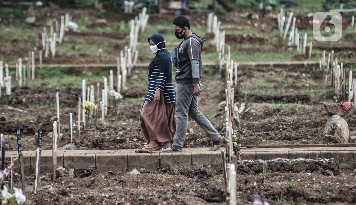 Warga berziarah ke makam kerabat di kompleks pemakaman protokol Covid-19, TPU Bambu Apus, Jakarta, Selasa (2/3/2021). TPU Bambu Apus kini tidak lagi menampung pemakaman jenazah protokol Covid-19 akibat lahan di dua blok sudah penuh dan dialihkan ke TPU Srengseng Sawah. (merdeka.com/Iqbal S Nugroho)