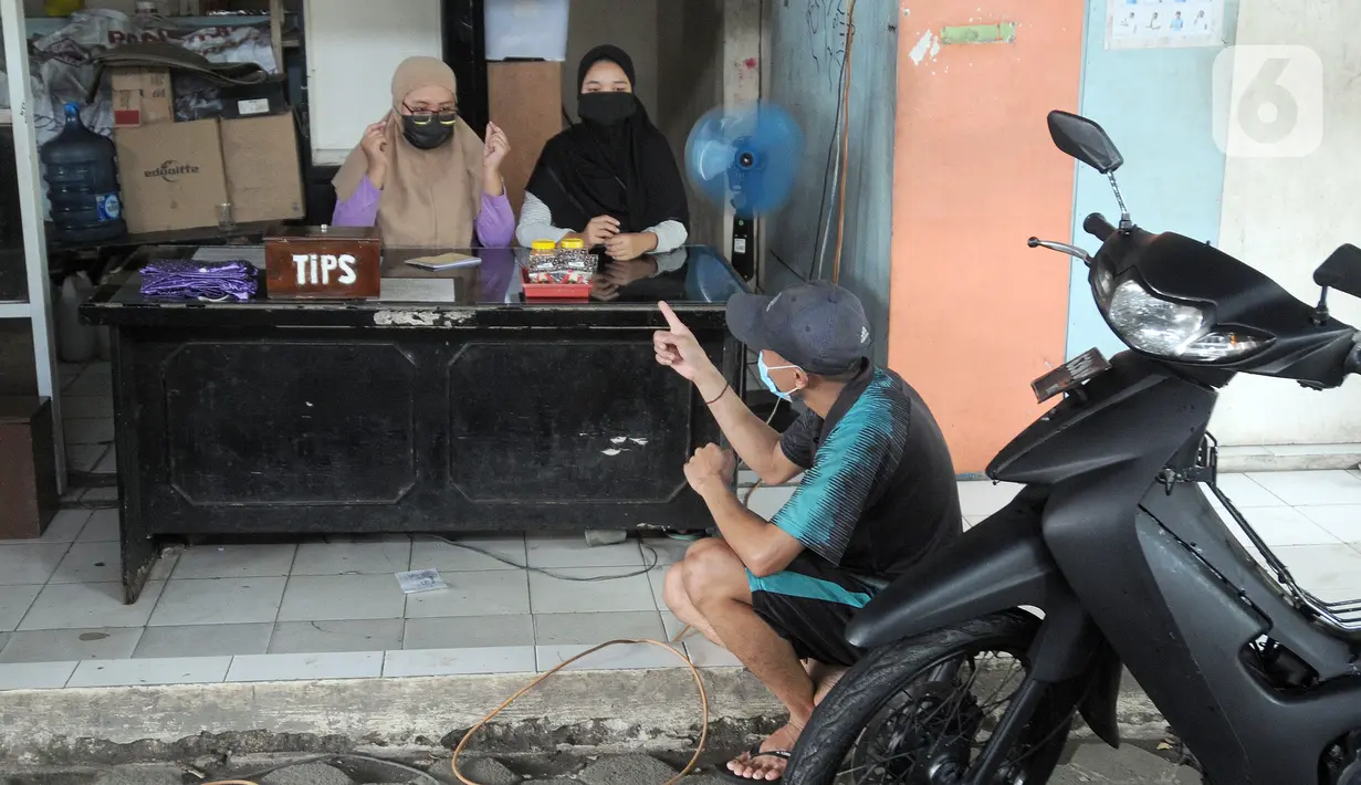 Karyawan penyandang tunarungu berkomunikasi menggunakan bahasa isyarat di Deaf Cafe and Car Wash di kawasan Cinere, Depok, Jawa Barat, Senin (27/9/2021). Seluruh karyawan di tempat cuci mobil-motor dan kafe ini merupakan penyandang tunarungu. (merdeka.com/Arie Basuki)