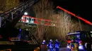 Petugas mengevakuasi rangkaian kereta komuter S-bahn yang tabrakan di Schaeftlarn di distrik Munich, Jerman pada 14 Februari 2022. Sekitar 95 orang berada dalam dua kereta yang mengalami kecelakaan itu dan seorang masinis terjebak di dalam kereta. (MICHAELA REHLE / AFP)