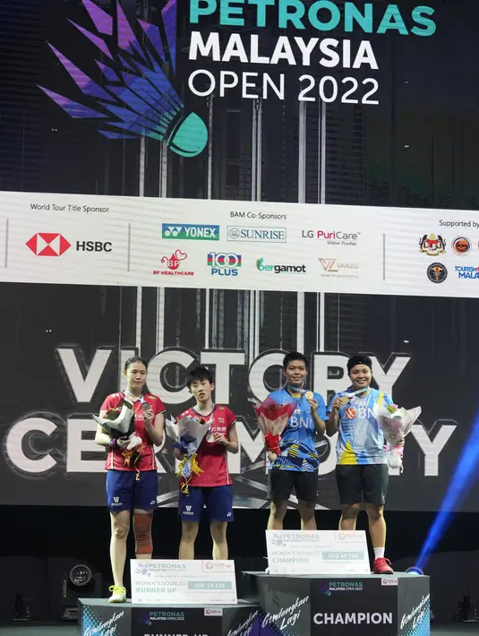 Ganda putri Indonesia Apriyani Rahayu/Siti Fadia Silva merayakan di podium dengan runner up China Zhang Shu Xian dan Zheng Yu dari China pada pertandingan final turnamen bulu tangkis Malaysia Open di Bukit Jalil Axiata Arena, Kuala Lumpur, Malaysia (3/7/2022). Apri/Fadia menang dengan skor 21-18, 12-21, dan 21-19. (AP Photo/Vincent Thian)