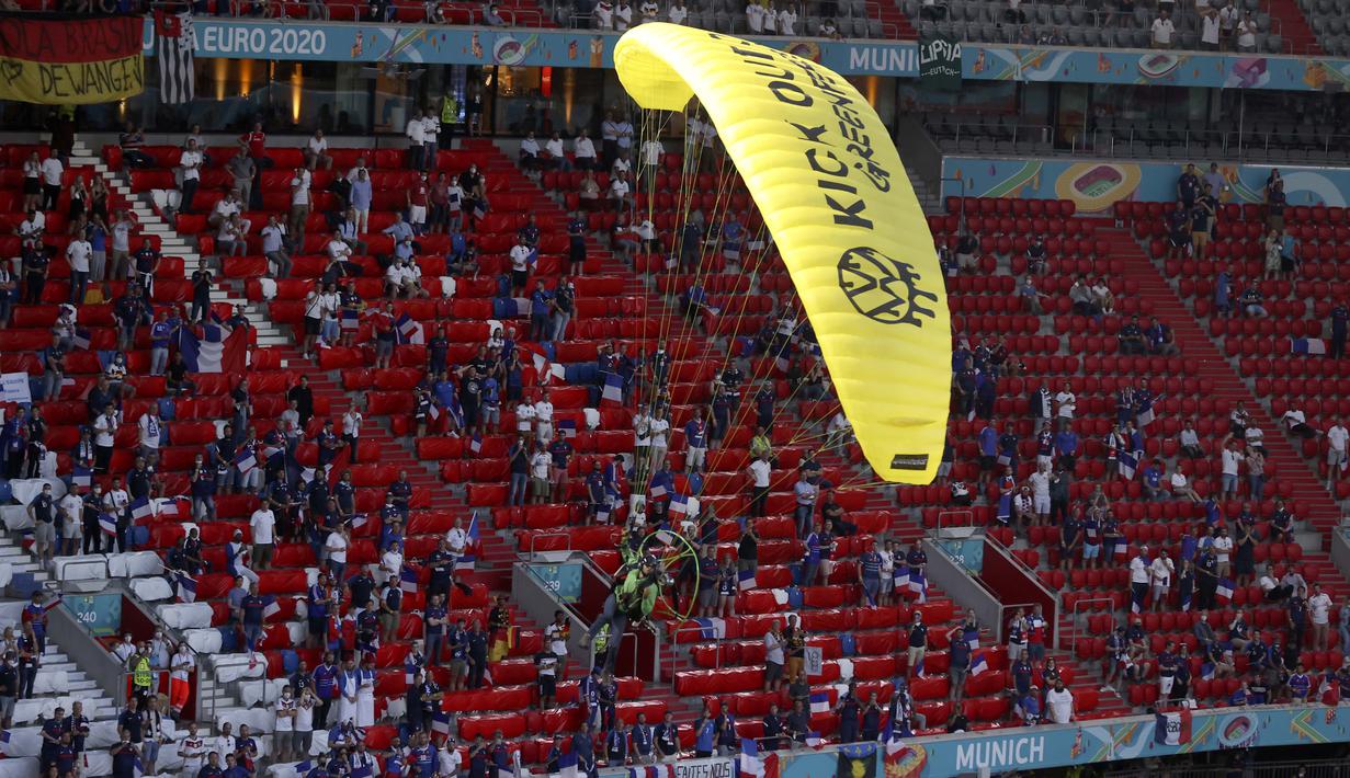 Aktivis tersebut hampir kehilangan kendali saat paraglidernya mau mendarat di tengah lapangan dan hampir menabrak para penonton di stadion. (Foto: AP/Pool/Alexander Hassenstein)