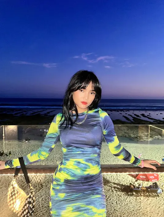 Pesona cantik Fuji mengenakan tie dye dress berwarna biru navy-kuning. Ia sempurnakan penampilannya dengan sentuhan kalung rantai, pulasan lipstik merah, rambut hitam sebahu berponi yang dibiarkan tergerai. [Foto: Instagram/fuji_an]