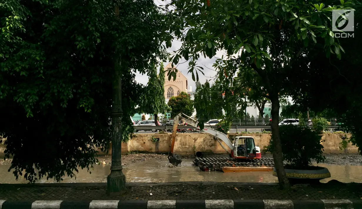 Pekerja mengeruk lumpur dan sampah yang mengendap menggunakan alat berat untuk di anak Sungai Ciliwung, Jakarta, Jumat (26/1). Selain itu, pengerukan juga dilakukan mengantisipasi banjir seiring datangnya musim hujan. (Liputan6.com/Immanuel Antonius)