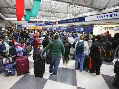 Pelancong mengantre untuk check-in penerbangan di Terminal 1 United Airlines menjelang Liburan Natal di Bandara Internasional O'Hare di Chicago (22/12/2022). Lebih dari 1.500 penerbangan dibatalkan di seluruh AS pada Kamis pagi karena badai musim dingin yang dahsyat membalikkan rencana perjalanan liburan dengan ancaman tiga kali lipat dari salju tebal, angin menderu, dan dingin yang menggigit. (AFP/Kamil Krzaczynski)