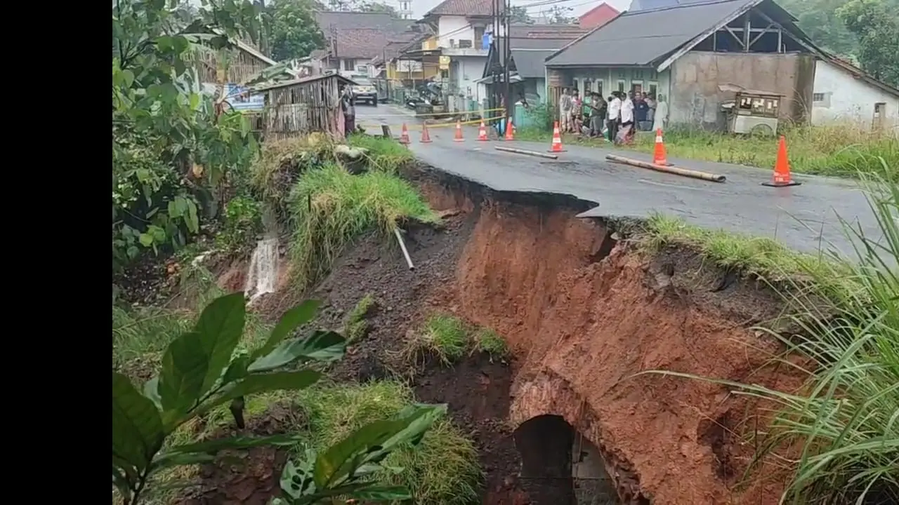 Nampak setengah bahu jalan Raya Mangunreja - Sukaraja, tepatnya di Kampung Cibeureum, Desa Tanjungjaya, Kecamatan Tanjungjaya, Kabupaten Tasikmalaya, Jawa Barat, longsor, Rabu (14/5/25) petang. (Liputan6.com/Jayadi Supriadin)