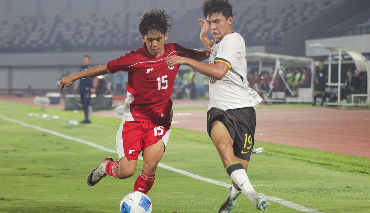 Pada laga ujicoba sebelumnya, tim asuhan pelatih Nova Arianto takluk dengan skor telak 0-7. Tampak dalam foto, pemain Timnas Indonesia U-17, Miraj Rizky Sulaeman (kiri) berebut bola dengan Ailikamu Yilihong (China) dalam laga uji coba di Indomilk Arena, Tangerang, Banten, Rabu (11/2/2026) malam. (Bola.com/Abdul Aziz)